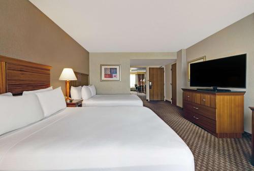 a hotel room with two beds and a flat screen tv at DoubleTree by Hilton Grand Junction in Grand Junction