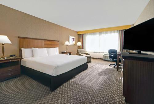 a hotel room with a bed and a flat screen tv at DoubleTree by Hilton Grand Junction in Grand Junction