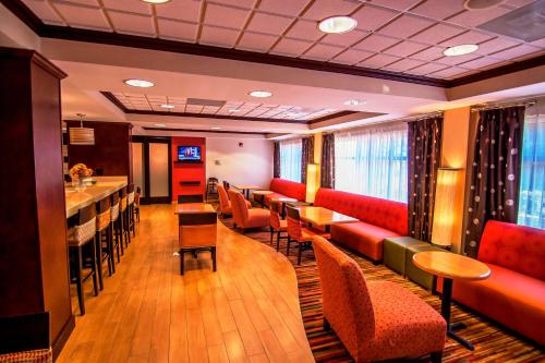 a restaurant with tables and chairs and a bar at Hampton Inn Groton/Mystic in Groton