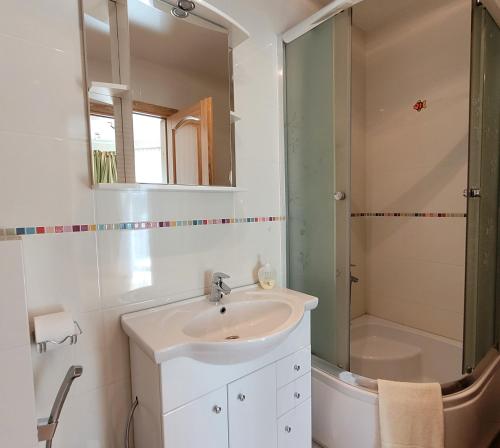 uma casa de banho com um lavatório e um chuveiro em Chalet Villa REX em Druskininkai