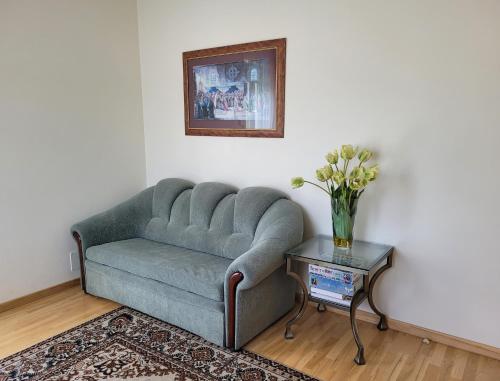 a living room with a couch and a table with flowers at Chalet Villa REX in Druskininkai