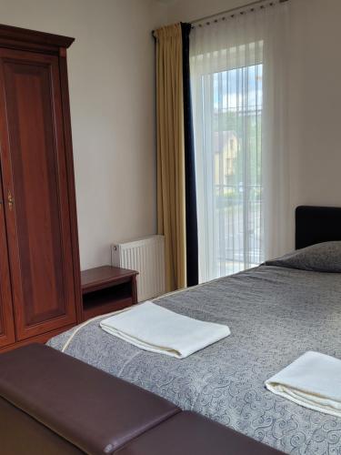 um quarto com uma cama com duas toalhas em Chalet Villa REX em Druskininkai