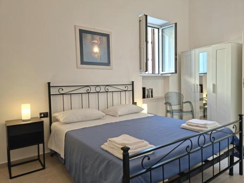 a bedroom with a bed with blue sheets and a mirror at Sorelle di Riviera in Syracuse