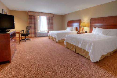 een hotelkamer met 2 bedden en een flatscreen-tv bij Hilton Garden Inn Great Falls in Great Falls