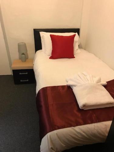 een slaapkamer met een bed met een rood kussen bij The Bugle Hotel in Titchfield