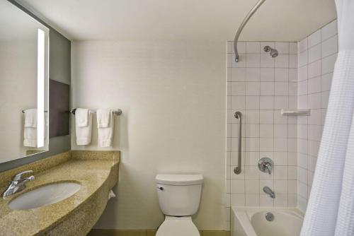 a bathroom with a toilet and a sink and a shower at Hilton Garden Inn Gulfport - Biloxi Airport in Gulfport