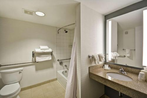 La salle de bains est pourvue de toilettes, d'un lavabo et d'un miroir. dans l'établissement Hilton Garden Inn Gulfport - Biloxi Airport, à Gulfport