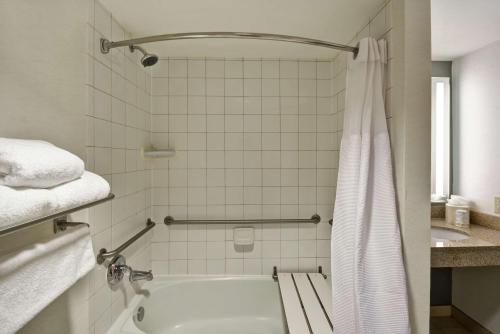 a bathroom with a white tub and a sink at Hilton Garden Inn Gulfport - Biloxi Airport in Gulfport