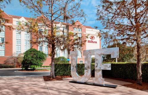 un panneau devant un bâtiment avec un hôtel dans l'établissement Hilton University of Florida Conference Center Gainesville, à Gainesville