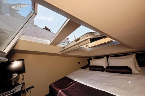 sypialnia z łóżkiem i dużym oknem w obiekcie Apartments Villa Markiz w Rovinj