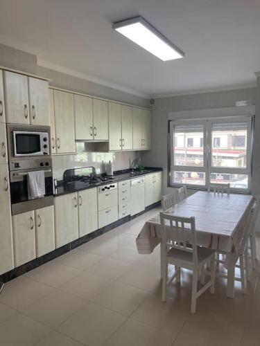 a large kitchen with a wooden table and a dining room at Piso MORRIÑA en Camariñas centro in Camariñas