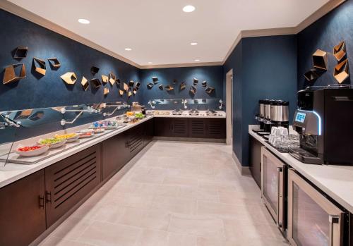 Una gran cocina con paredes azules y un baño. en Hilton University of Florida Conference Center Gainesville, en Gainesville