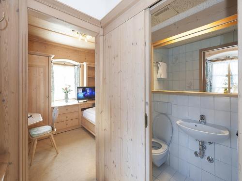 ein Bad mit einem WC und einem Waschbecken in der Unterkunft Hotel Garni Bernhard am See in Walchsee