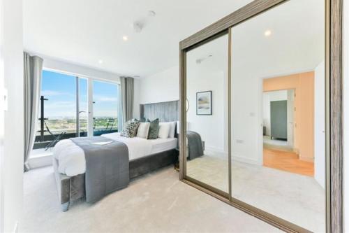 ein Schlafzimmer mit einem Bett und einem großen Spiegel in der Unterkunft Spacious one bedroom luxury apartment in Kidbrooke Greenwich in London