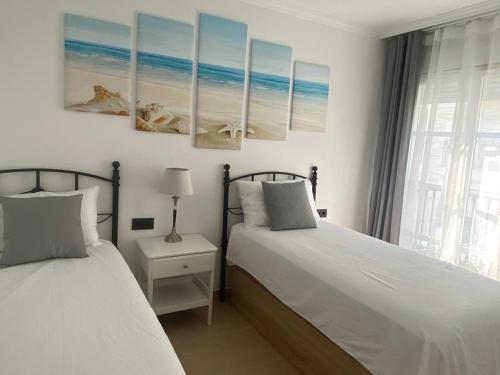 a bedroom with two beds and a window at Beach Apartment La Cala de Mijas in La Cala de Mijas