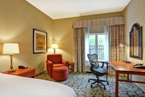 a hotel room with a bed and a desk and chair at Hilton Garden Inn Hattiesburg in Hattiesburg