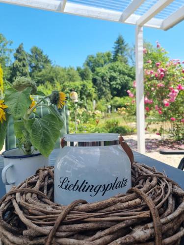 a jar sitting on a table next to a plant at Ferienhaus Am Fehntjer Tief in Emden
