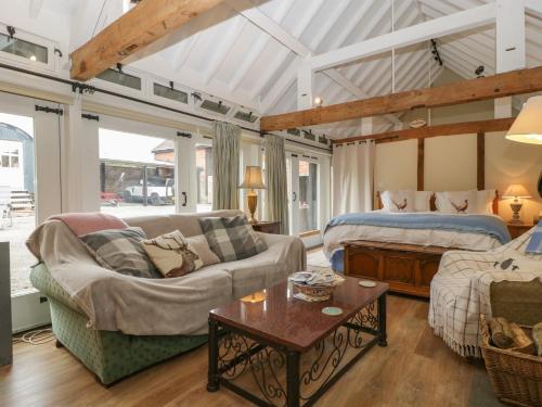 a bedroom with a bed and a couch and a table at Walnut Cottage in Ross on Wye