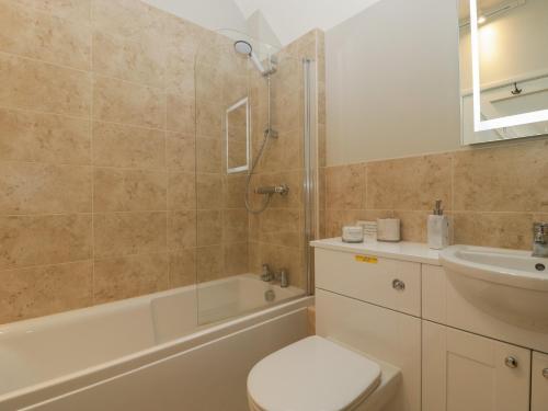 a bathroom with a toilet and a tub and a sink at Walnut Cottage in Ross on Wye