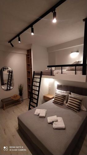 een slaapkamer met een groot bed en 2 stapelbedden bij Modern and Sunny Studio Kavala in Kavala