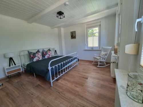 a bedroom with a bed in a room with wooden floors at Ferienhaus Am Fehntjer Tief in Emden