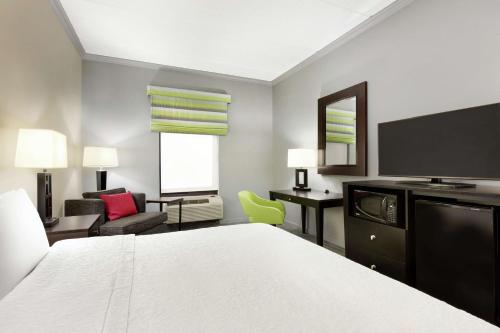 Habitación de hotel con cama y TV en Hampton Inn and Suites Houston Clear Lake NASA, en Webster