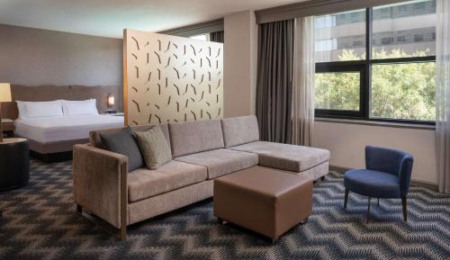 a hotel room with a couch and a bed at Hilton Houston North in Houston