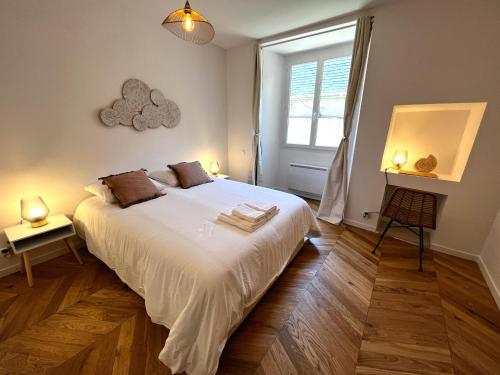 una camera da letto con un grande letto bianco e una finestra di Le Petit Palais Notre Dame - Heart of Dijon a Digione