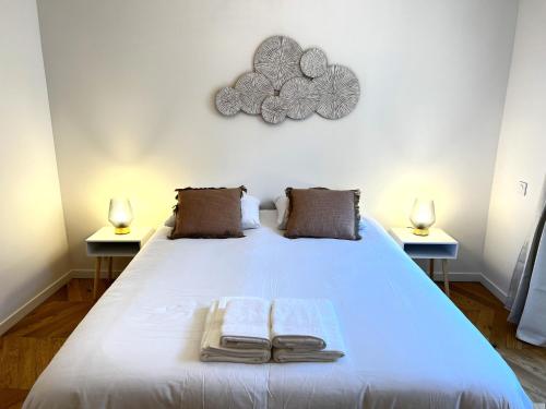 een slaapkamer met een groot wit bed met 2 lampen bij Le Petit Palais Notre Dame - Heart of Dijon in Dijon