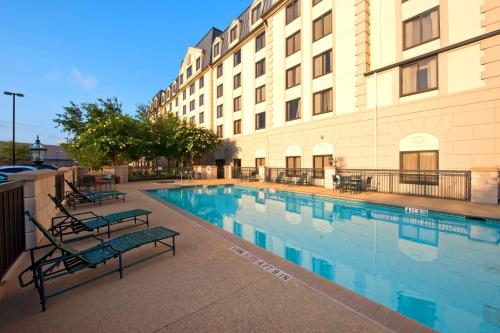 a hotel with a swimming pool in front of a building at Hilton Garden Inn Houston Northwest in Houston
