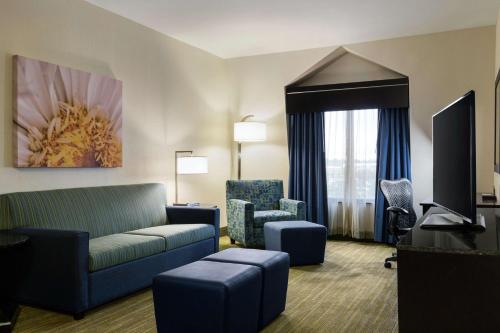 a living room with a couch and chairs in a hotel room at Hilton Garden Inn Houston Northwest in Houston