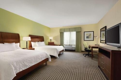 um quarto de hotel com duas camas e uma televisão de ecrã plano em Hilton Garden Inn Houston/Clear Lake NASA em Webster