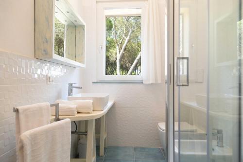baño con lavabo y aseo y ventana en Dimora La Fiumara, en Marina di Grosseto