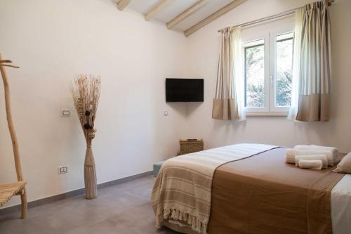 a bedroom with a bed and a vase of flowers at Dimora La Fiumara in Marina di Grosseto