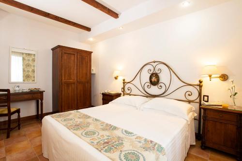 a bedroom with a large bed with a white bedspread at Fattoria La Principina Hotel & Congress in Principina Terra