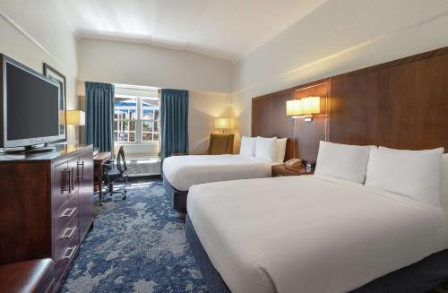 a hotel room with two beds and a flat screen tv at DoubleTree by Hilton Cape Cod - Hyannis in Hyannis