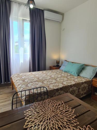 ein Schlafzimmer mit einem großen Bett und einem Fenster in der Unterkunft Casa M 1 in Donja Lastva