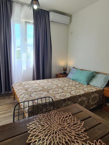 a bedroom with a large bed and a window at Casa M 1 in Donja Lastva