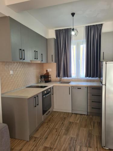 eine Küche mit weißen Schränken, einer Spüle und einem Kühlschrank in der Unterkunft Casa M 1 in Donja Lastva