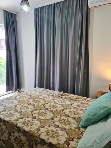 ein Schlafzimmer mit einem großen Bett mit einer Blumenbettdecke in der Unterkunft Casa M 1 in Donja Lastva