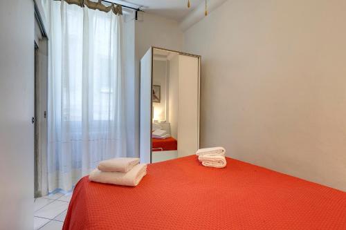 1 dormitorio con cama roja y espejo en Magico Risveglio agli Uffizi, en Florencia