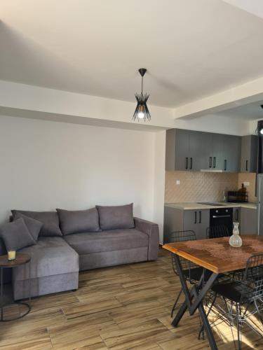 ein Wohnzimmer mit einem Sofa und einem Tisch in der Unterkunft Casa M 1 in Donja Lastva