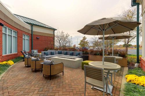 a patio with a table and chairs and an umbrella at Hilton Garden Inn Indianapolis Airport in Plainfield