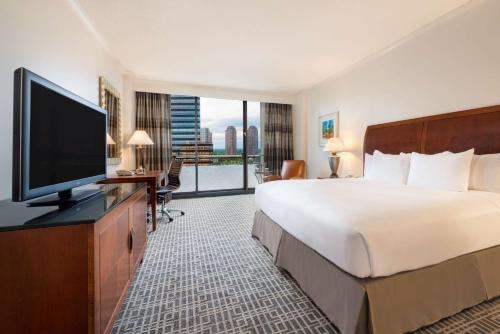 a hotel room with a large bed and a flat screen tv at Hilton Houston Post Oak by the Galleria in Houston