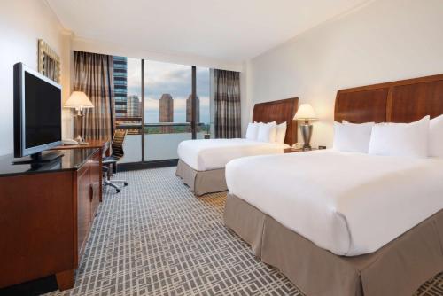 a hotel room with two beds and a flat screen tv at Hilton Houston Post Oak by the Galleria in Houston