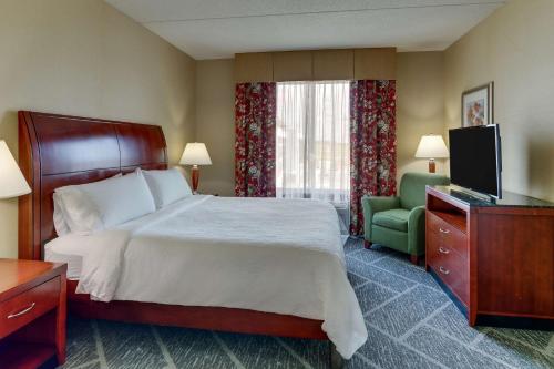 Hilton Garden Inn Indianapolis Airport في بلينفيلد: غرفه فندقيه سرير وتلفزيون