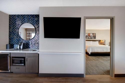 a kitchen with a tv on a wall in a room at Hilton Garden Inn Terre Haute in Terre Haute