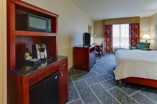 a hotel room with a bed and a flat screen tv at Hilton Garden Inn Indianapolis Airport in Plainfield