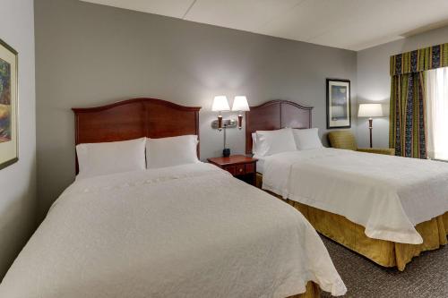 a hotel room with two beds with white sheets at Hampton Inn & Suites Indianapolis-Airport in Indianapolis
