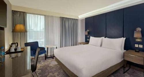 a bedroom with a large white bed and a blue wall at DoubleTree by Hilton Lincoln in Lincoln